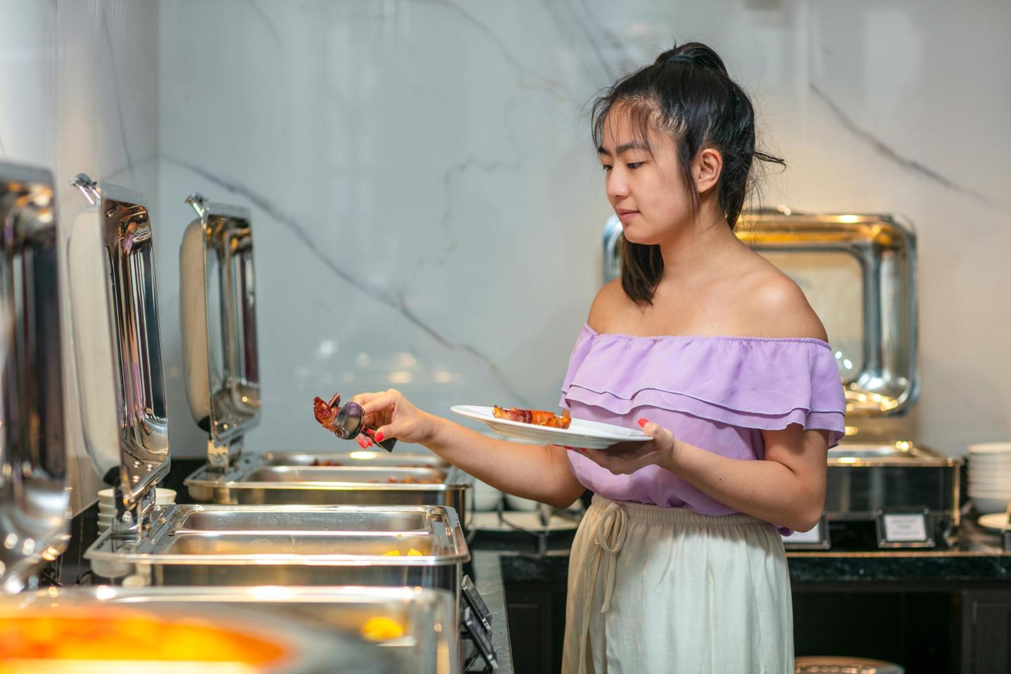 May De Ville Lakeside Hotel Hanoi Bagian luar foto A woman serving herself at a buffet
